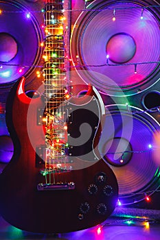 Abstract guitar with festive Christmas lights and music speakers