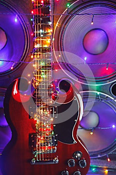 Abstract guitar with festive Christmas lights and music speakers