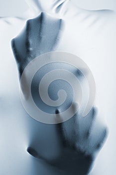 Abstract hands, human arm inside fabric, toned blue