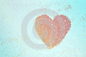Abstract heart of golden glitter sparkles on blue background