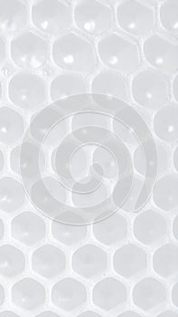 Abstract hexagonal pattern of white foam bubbles and light reflections
