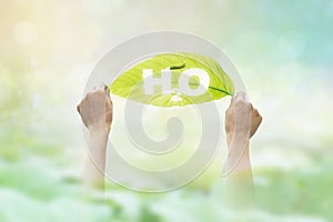 Abstract, holding a green leaf in the word H2O on vibrant nature