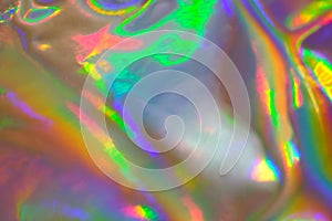 Abstract holographic iridescent foil texture background with rainbow colored spots photo