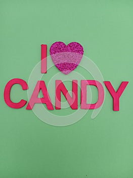 Abstract I love candy sign with a heart shape instead of the word love on a green background