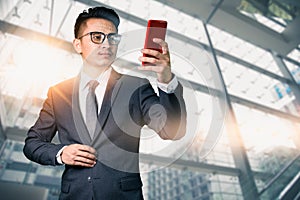 The abstract image of the businessman using a smartphone overlay with futuristic hologram. The concept of modern life, technology,
