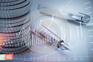 Abstract image of coin stack, pen and candlestick forex chart on blurry desktop backdrop. Trade, money and financial growth