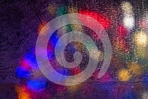 abstract image of colored lights coming from colorful church stained glass projected onto cement floor