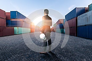 The abstract image of engineer standing in the container yard during sunrise. the concept of engineering, shipping, shipyard, busi