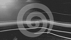 Abstract black and white image featuring streaks of light across a dark background