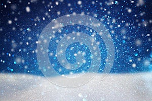 abstract image of flying snow over dark blue background, winter season.