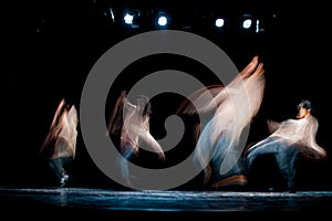 Abstract image of hip-hop dancers performing on a stage