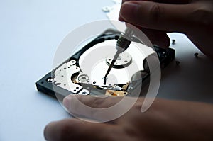 The abstract image of inside of hard disk drive with technician fixing using screw driver. Concept of data, hardware
