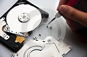 The abstract image of inside of hard disk drive with technician fixing using screw driver. Concept of data, hardware