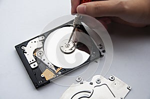 The abstract image of inside of hard disk drive with technician fixing using screw driver on white background. Concept