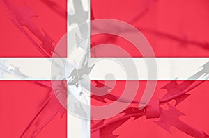 Abstract image of the national flag of Denmark with twisted barbed wire.