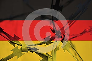 Abstract image of the national flag of Germany with twisted barbed wire