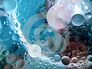 Abstract image of oil and water in a glass bowl sitting on a colorful surface