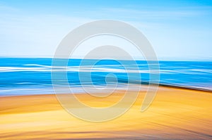 Abstract image of a serene empty beach with golden sand and azure blue water in summer