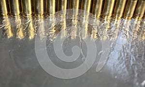 Abstract image with silver and gold brass surfaces, gun bullets line