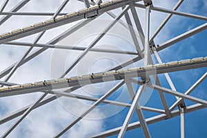 Abstract image of white steel struts and supports in front of a white-blue sky