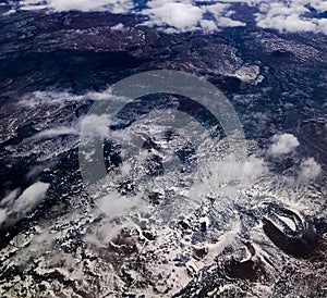 Abstract imagery of aerial view of mountains, rugged terrain, and clouds photo