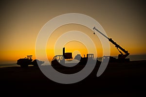 Abstract Industrial background with construction crane silhouette over amazing sunset sky. Mobile crane against the evening sky.