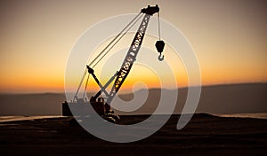 Abstract Industrial background with construction crane silhouette over amazing sunset sky. Tower crane against the evening sky.