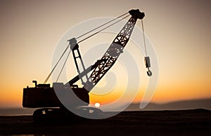 Abstract Industrial background with construction crane silhouette over amazing sunset sky. Tower crane against the evening sky.