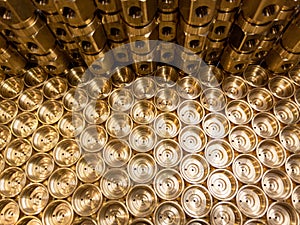 An abstract industrial close-up background of shiny brass metal threaded hexagonal fitting parts