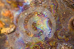 Abstract irridescent rainbow rusted orange and brown metal surface photo