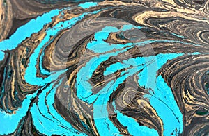 Abstract liquid gold background. Pattern with abstract golden and black waves. Marble. Handmade surface. Liquid paint.