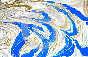 Abstract liquid gold background. Pattern with abstract golden and black waves. Marble. Handmade surface. Liquid paint. Draw, mater