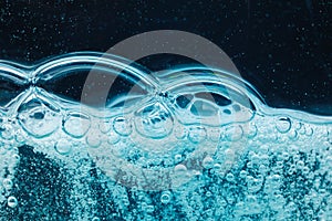 Abstract liquid soap bubbles blue background