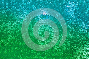 Abstract liquid soap bubbles green background