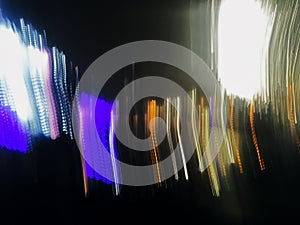 Abstract long exposure defocused photo of neon lines of city lights of phantom blue, yellow and white colors at night