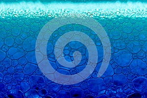 Abstract macro clean blue foam shot background of soap bubbles with light and color reflections effects