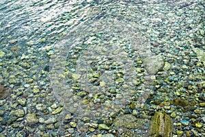 Abstract sea background with water covering stones and pebbles. Vertical orientation