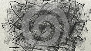 An abstract, messy charcoal scribble on a piece of textured white paper.