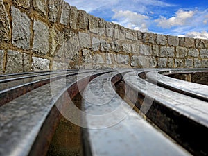 Abstract metal bench rails seating brick wall