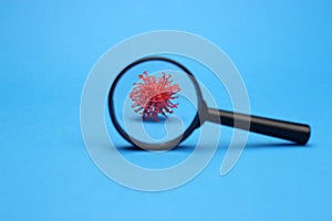 Abstract model of a coronavirus in the selective focus of a magnifying glass