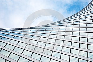 Abstract modern architecture, glass building structure, wave shape building detail in blue sky