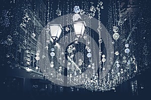 Abstract monochromatic Christmas street with illumination, burning lantern closeup, Christmastide, modern background photo