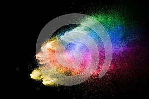 Abstract multicolored powder explosion on black background. Color dust particle splattered on background