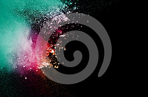 Abstract multicolored powder explosion on black background. Color dust particle splattered on background