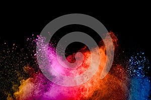 Abstract multicolored powder explosion on black background.Colorful dust particles splatter on background