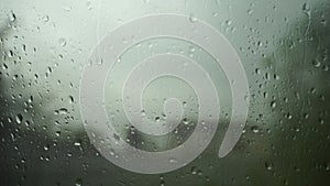 Abstract natural pattern of raindrops isolated on cloudy background. Drops randomly sliding on wet car glass surface