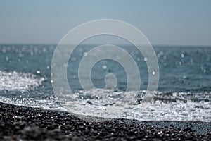 Abstract nature summer ocean sunset sea background. Small waves on water surface in motion blur with bokeh lights from