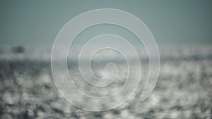 Abstract nature summer or spring ocean sea background. Small waves on water surface in motion blur with bokeh lights