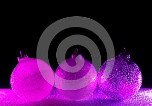 Abstract neon purple and pink gradient glitter glass Christmas baubles background with copy space.