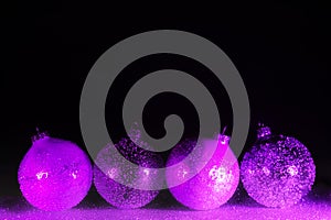 Abstract neon purple and pink gradient glitter glass Christmas baubles background with copy space.